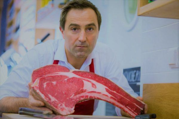 Portrait of a butcher with meat