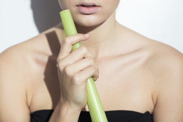 Close up of a young woman holding a leek