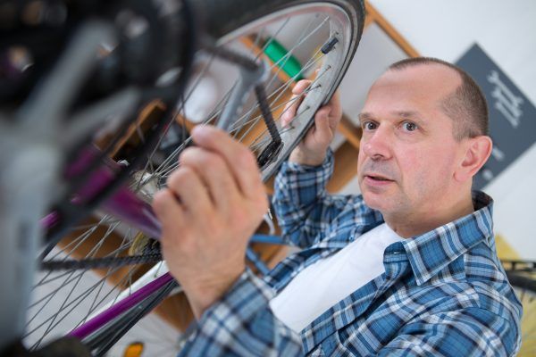 technician fixing bicycle in repair shop
