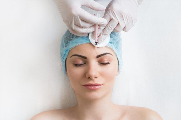 Frau erhält kosmetische Botox Spritze ins Gesicht