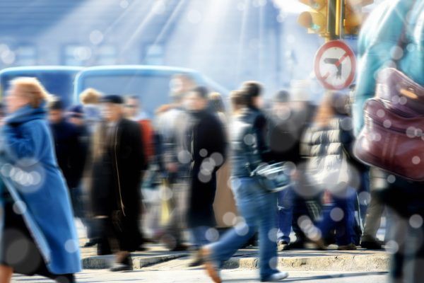 blurry background image of people walking on busy street