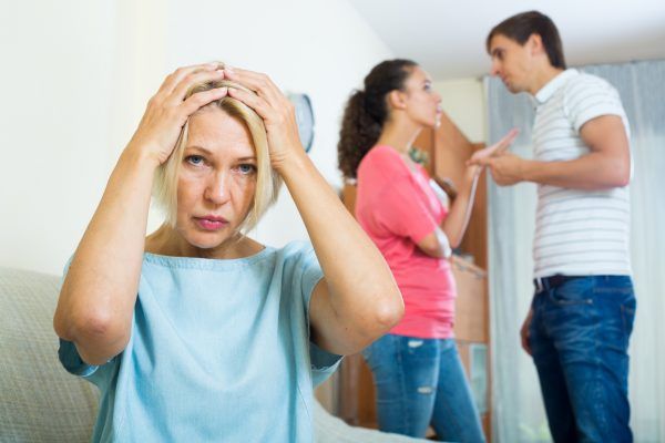 Husband and wife quarrelling indoors, senior mother taking it hard