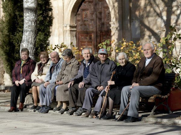 CU03.OLMEDA DE LA CUESTA, Cuenca, 23/1/2011.- Varios ancianos toman el sol en unos bancos de Olmeda de la Cuesta, Cuenca, el municipio más envejecido de España, con un 81,3% de personas mayores de 65 años, según recoge el cuaderno "La población en España:1900-2009" elaborado por la Fundación BBVA y el Ivie. El Ayuntamiento de Olmeda de la Cuesta sacará a subasta varios solares a precios muy económicos para atraer población a una localidad en la que no nace nadie desde hace más de cuarenta años. EFE/Santiago Torralba