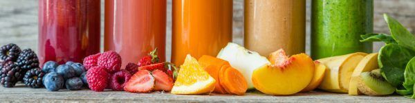 Selection of colourful smoothies on rustic wood background, copy space