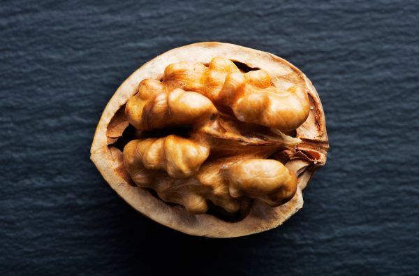 close-up view of cracked walnut on slate background
