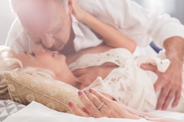 Shot of an elderly couple kissing on a bed
