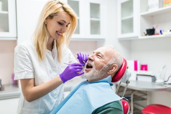 Senior man having dental treatment at dentist's office.